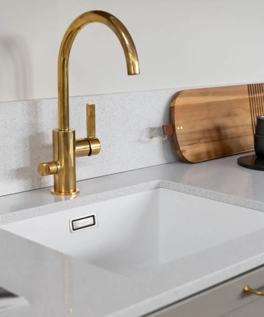 Valkoinen allas upotettu messinki hanalla